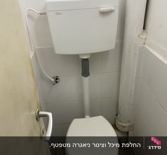 אסלה עם מיכל הדחה וצינור מים מחובר